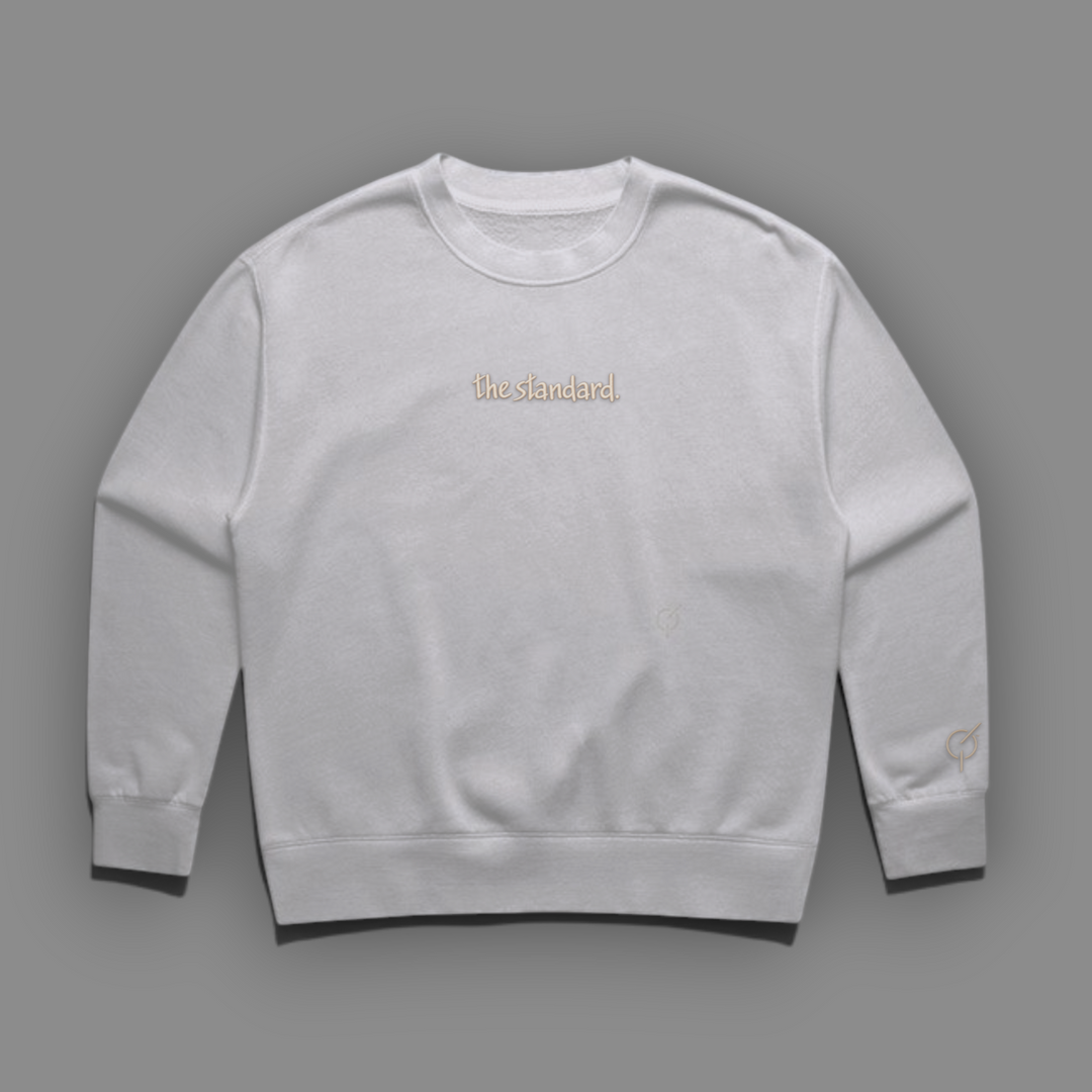 The Standard Faded Crewneck in faded bone with the standard. embroidered with sand colored thread on the chest.