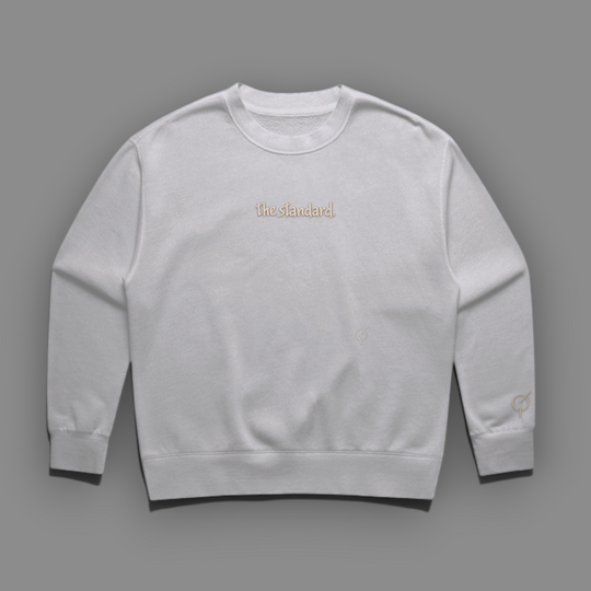 The Standard Faded Crewneck in faded bone with the standard. embroidered with sand colored thread on the chest.