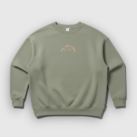 area 609 sage green crewneck sweatshirt featuring a small embroidered Preservation arch logo on the chest