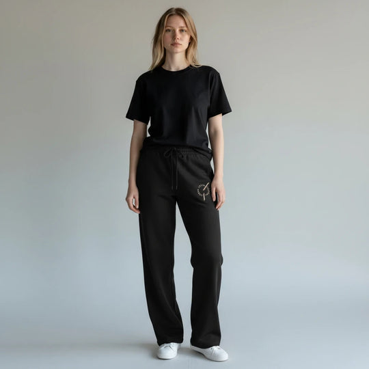 Model wearing area 609 black organic cotton French terry wide leg pants with embroidered Founders Mark logo.
