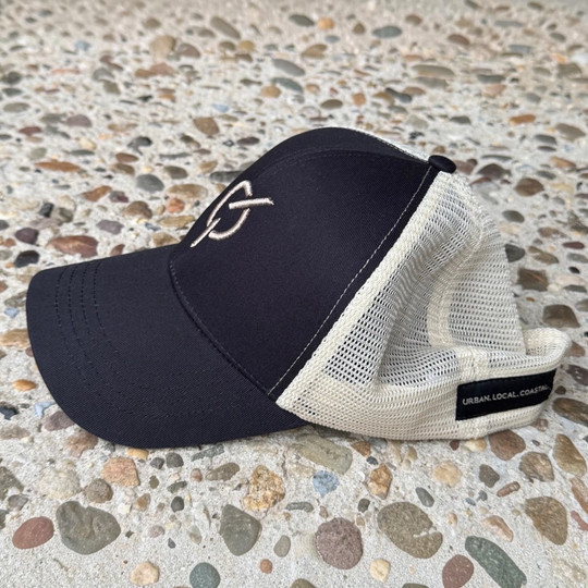 area 609 The Core Trucker hat in black organic cotton with an oyster mesh back and raised puff embroidered emblem.