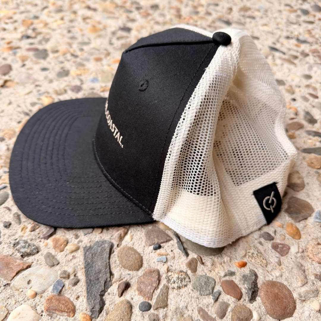 area 609 The Founders trucker hat in black cotton with an ecru mesh back, flat peak, and side woven label.