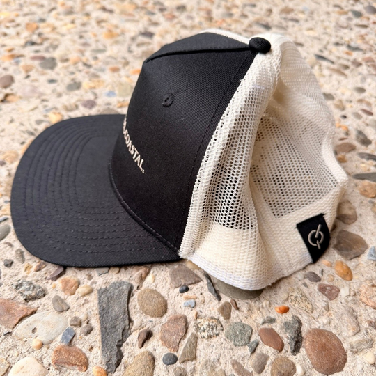area 609 The Founders trucker hat in black cotton with an ecru mesh back, flat peak, and side woven label.